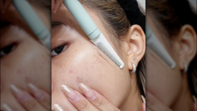 Woman dermaplaning at home