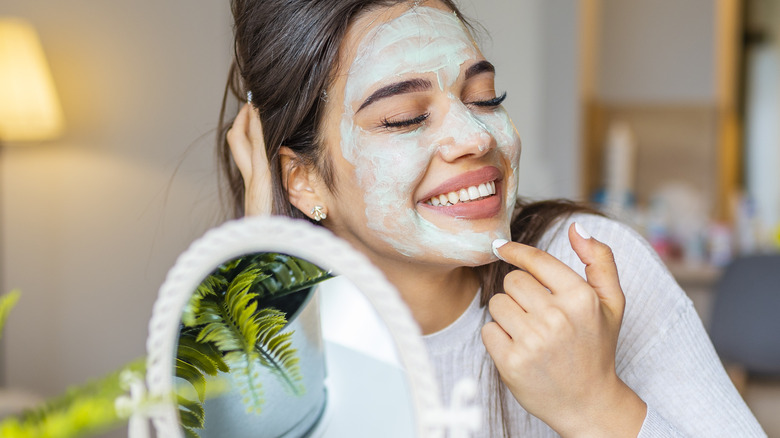 Woman applying exfoliating mask