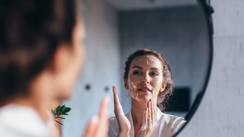 Woman using face soap cleanser