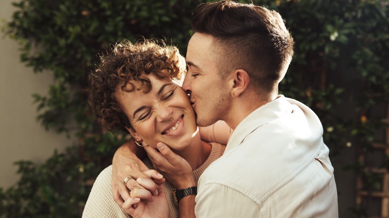 Man kissing woman on her cheek