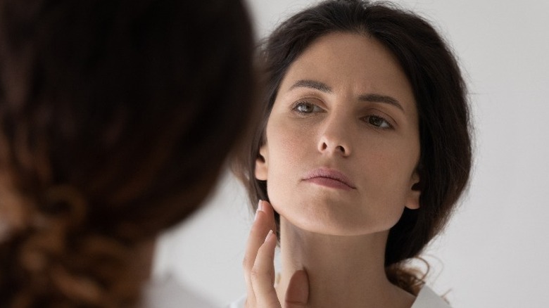 Woman looking at face in mirror