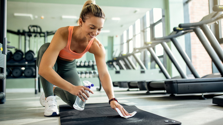 Woman wiping yoga mat