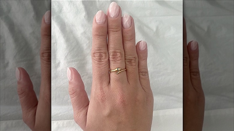 hand with rose quartz dip nails