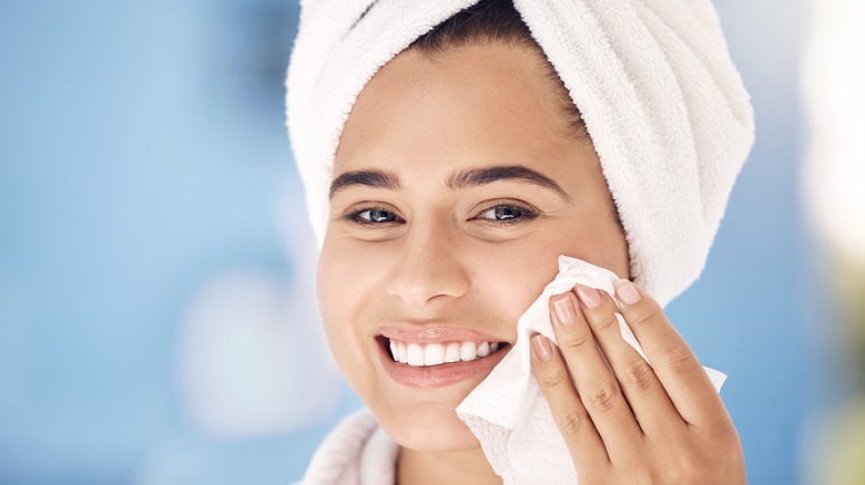 Woman using a wipe on her face