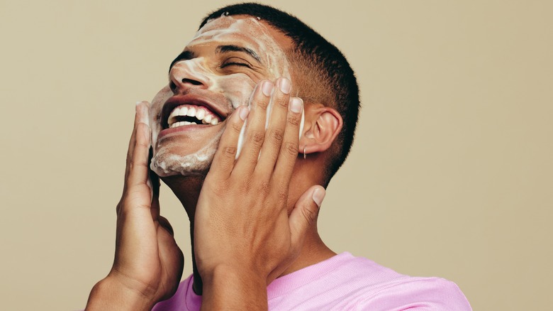 Man washing his face with soap