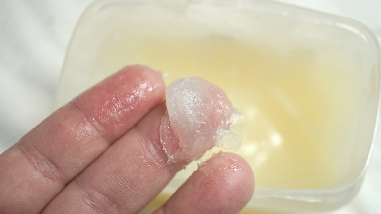 Person applying petroleum jelly to hands