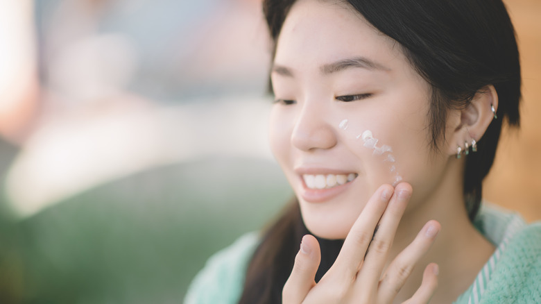 smiling woman using barrier cream