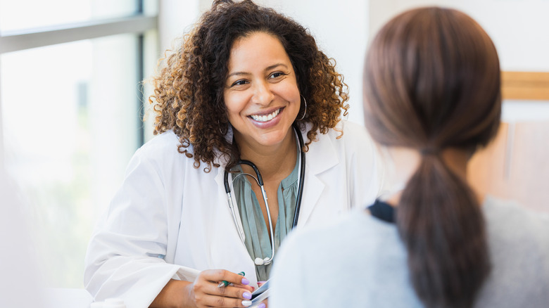 woman talking to smiling doctor