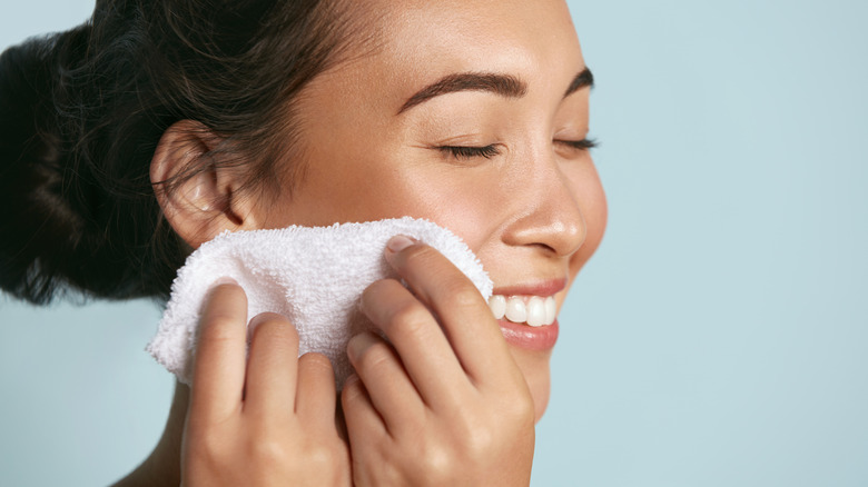 woman drying face with towel