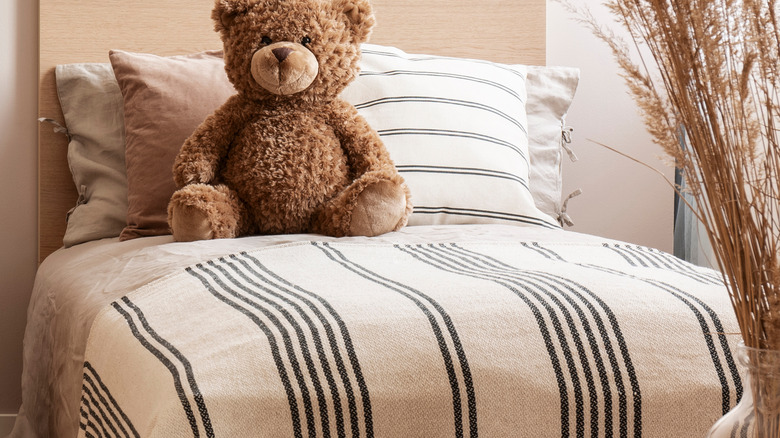 a bed with a teddy bear on