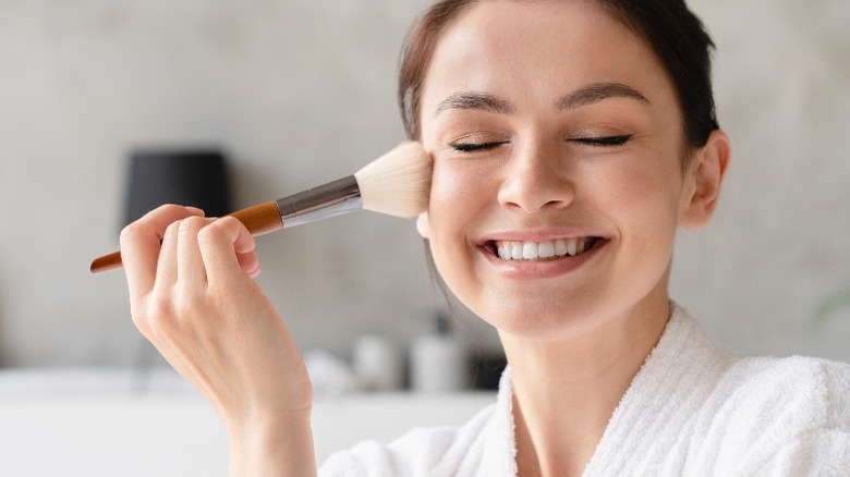 Woman using makeup brush