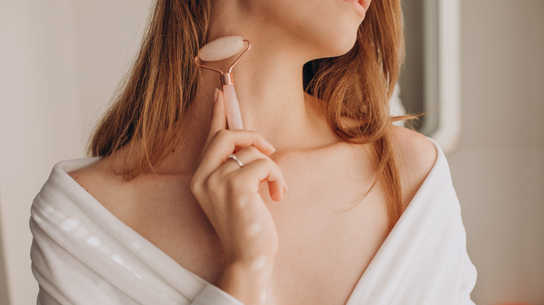 woman using quartz roller on neck