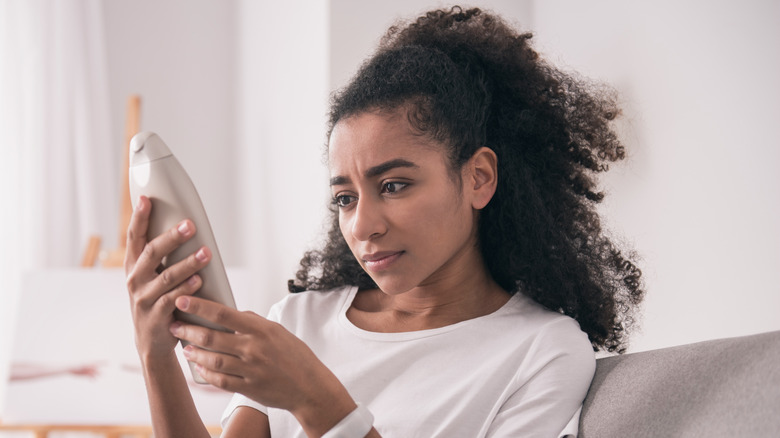 woman reading lotion bottle