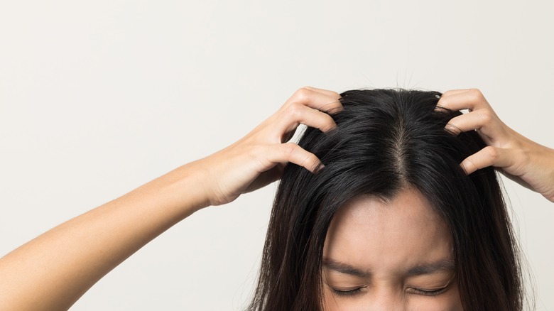 woman rubbing scalp