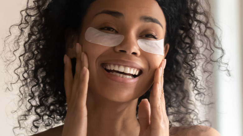 woman applies patches under her eye