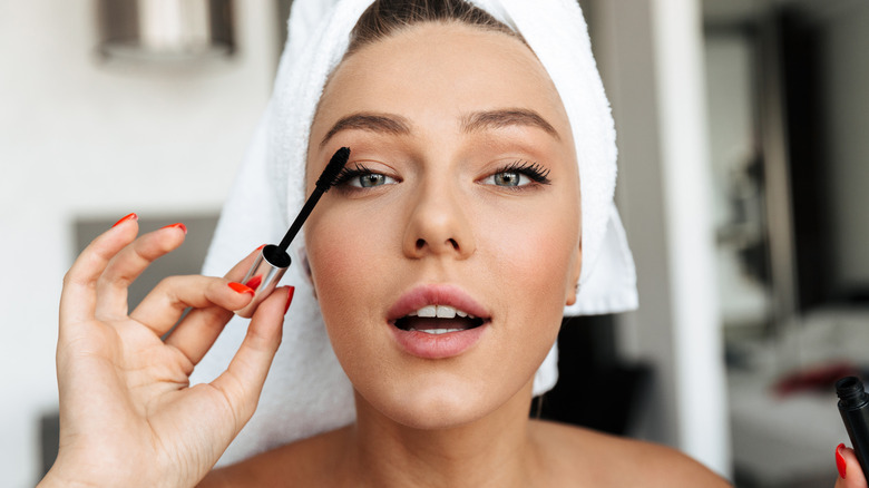 A woman applying mascara 