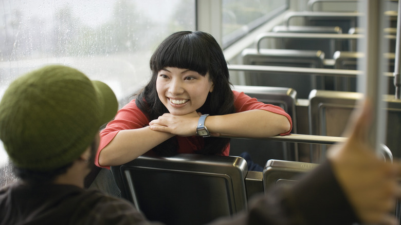 Woman on train smiling at man