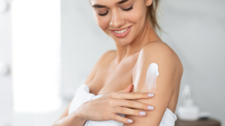 Woman applying moisturizer 