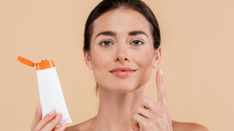 Woman applying skincare product