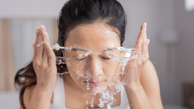 woman using water to wash face