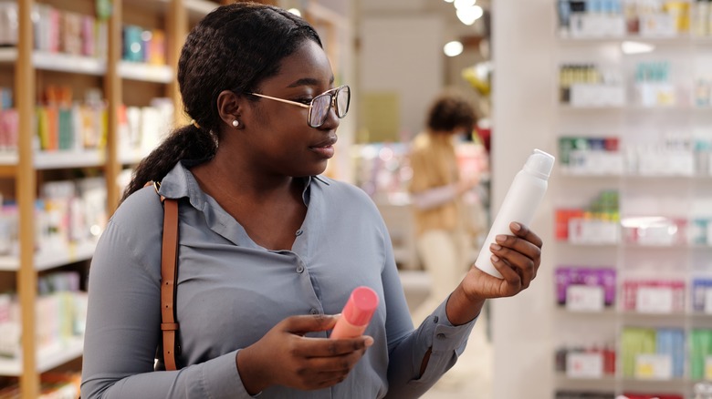 Woman examining deodorant products