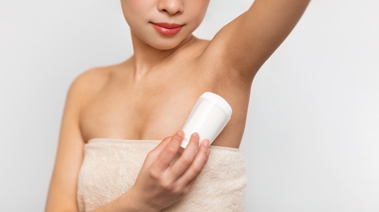 Woman applying solid deodorant