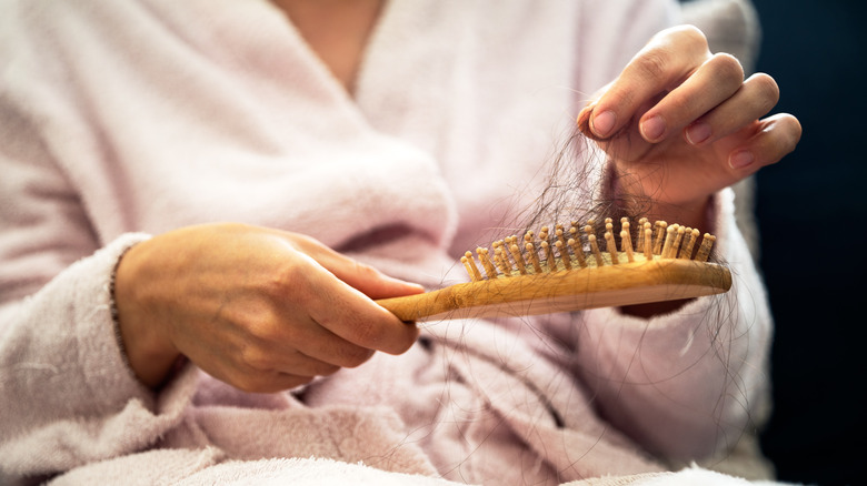 Person pulling hair from brush