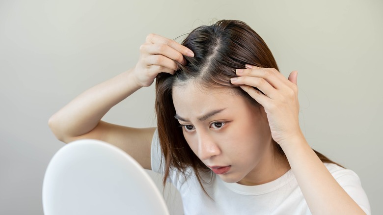 Girl inspecting thinning hair