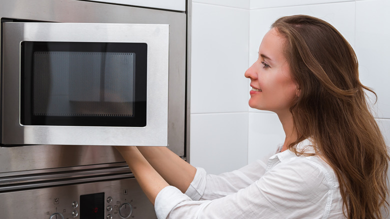 Woman using microwave 