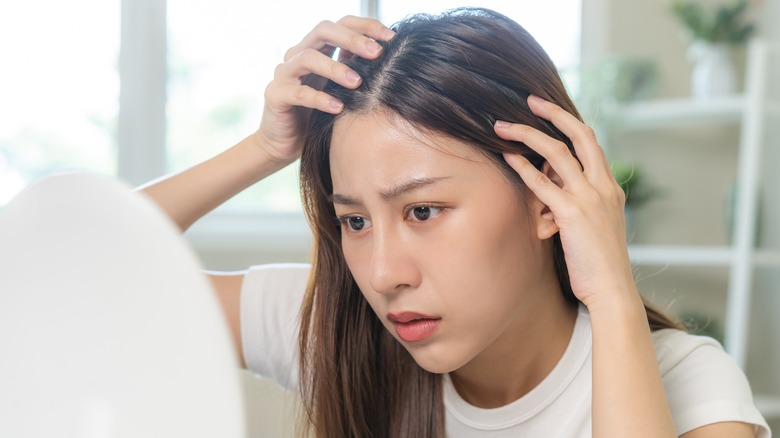 Woman with thinning hair looking in mirror 