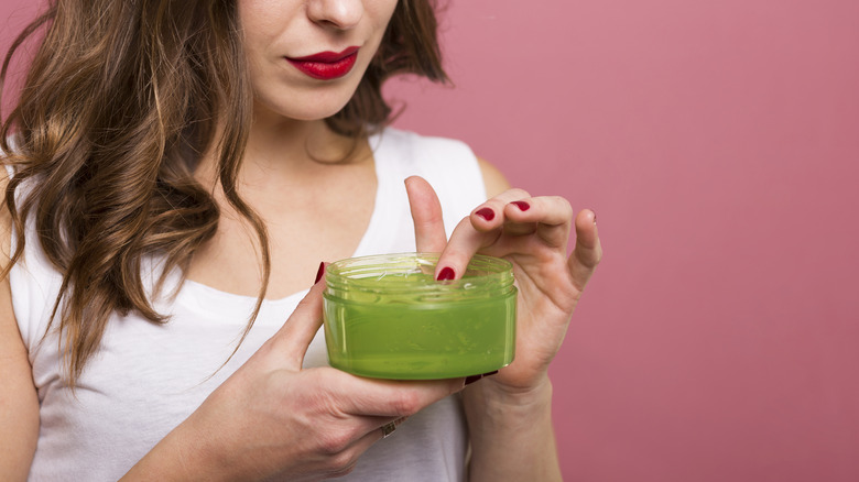 woman holding hair gel bottle