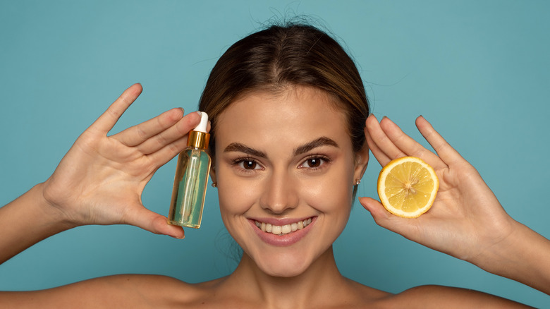 Girl holding lemon and vitamin C serum