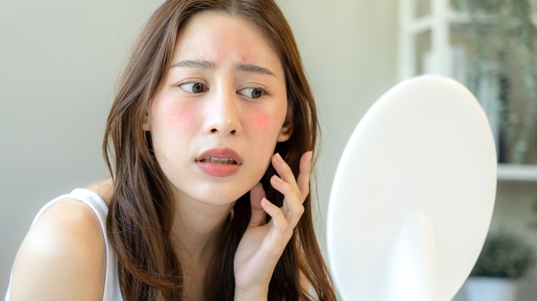 Worried girl with red, flaky skin 