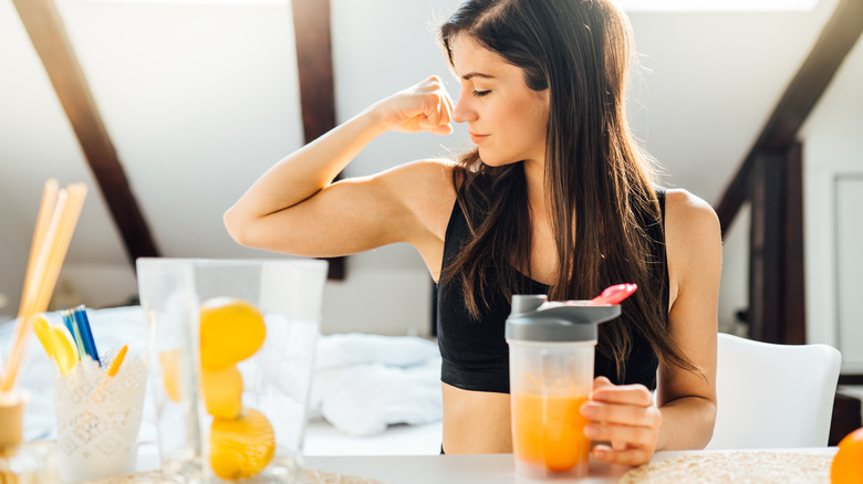 women flexing drinking pressed juice