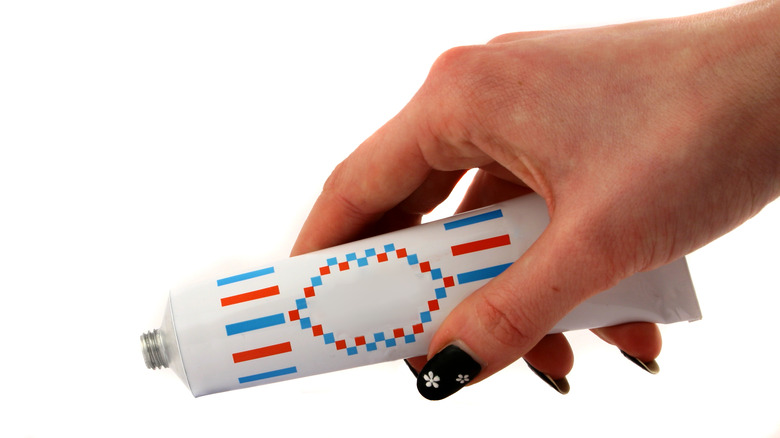 hand holding a toothpaste tube
