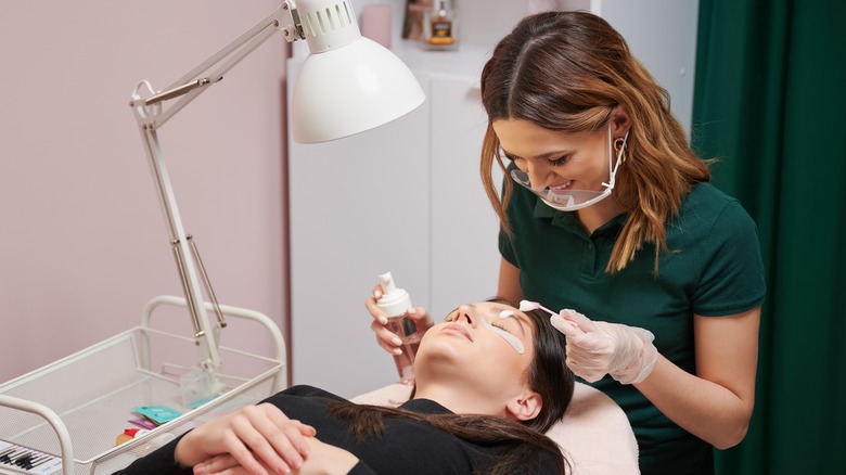 Woman with eyelash extension technician 