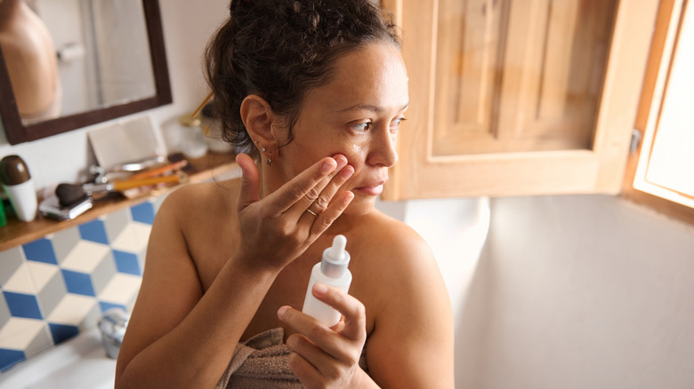 A woman applying skincare.