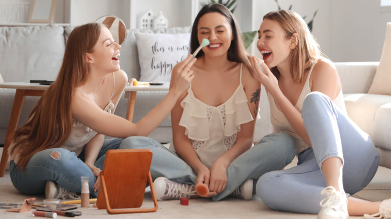 Women doing their makeup together.