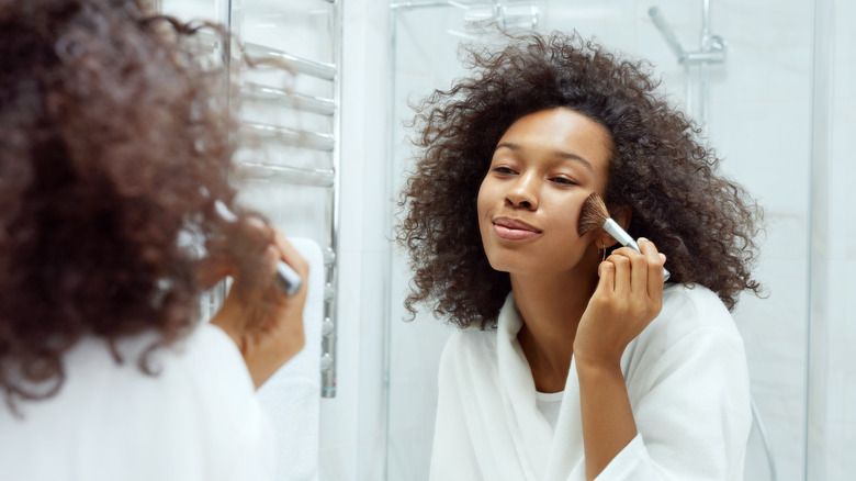 woman applying face makeup