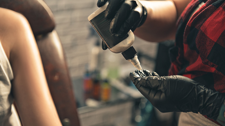 Tattoo artist applying disinfectant