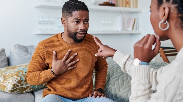 Woman pointing at defensive man