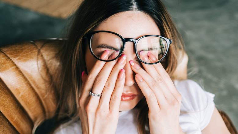 Woman rubs her dry, tired eyes