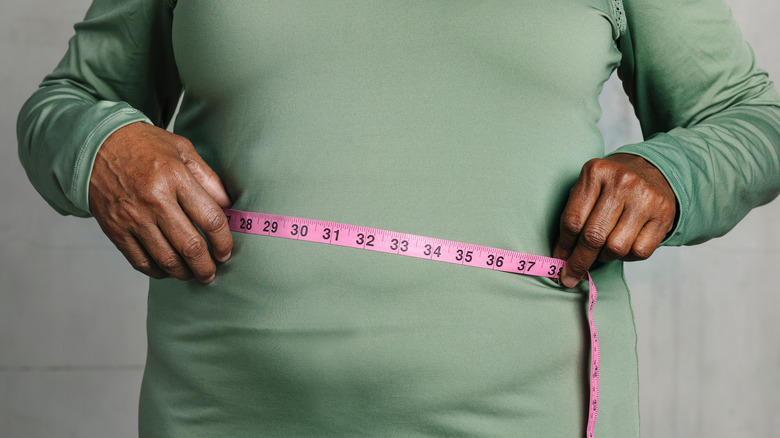 Black woman measuring stomach