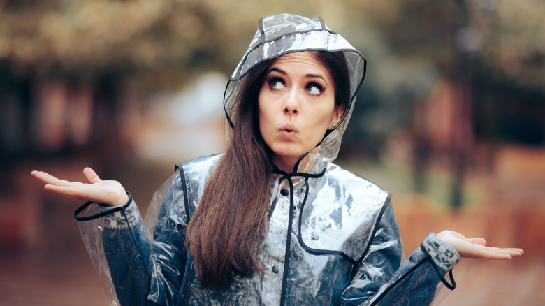 Surprised woman in rain poncho