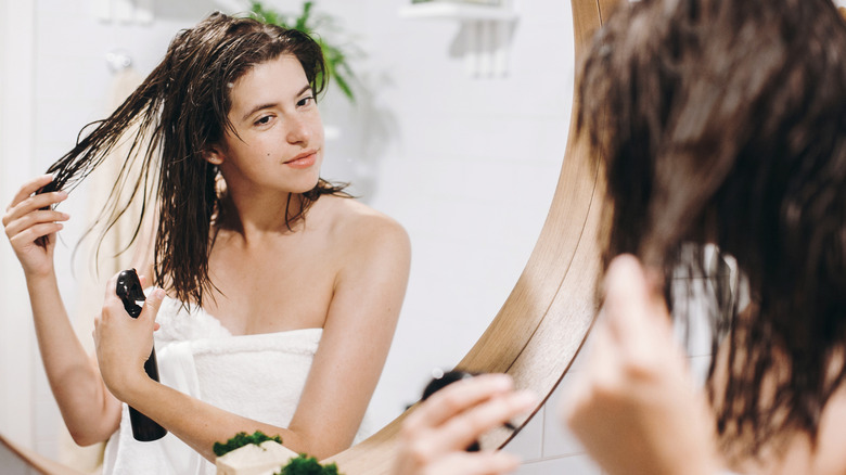 woman adding hair product 