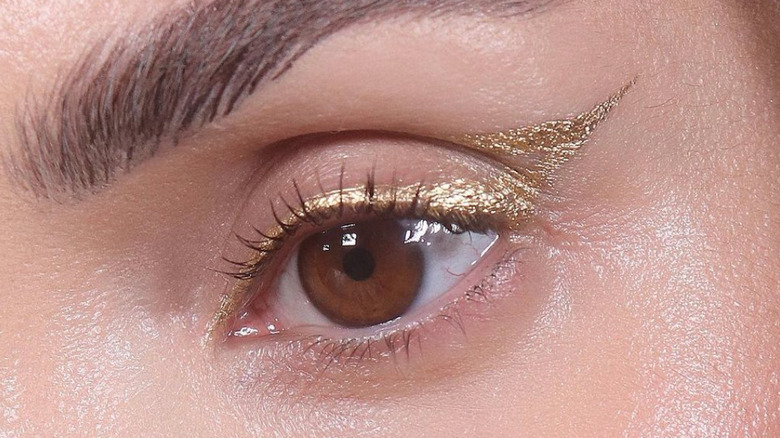 A woman wearing golden eyeliner