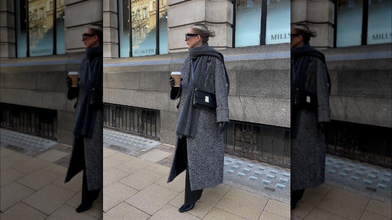 Woman layering scarf over coat 