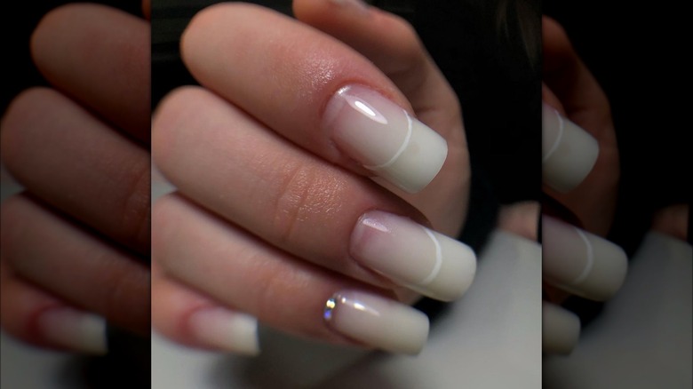 White nail design with rhinestone