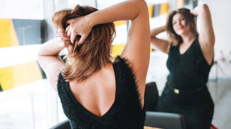 A woman looking at herself in the mirror.