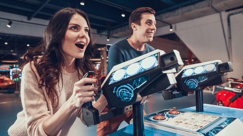 Couple playing aim and shoot arcade game